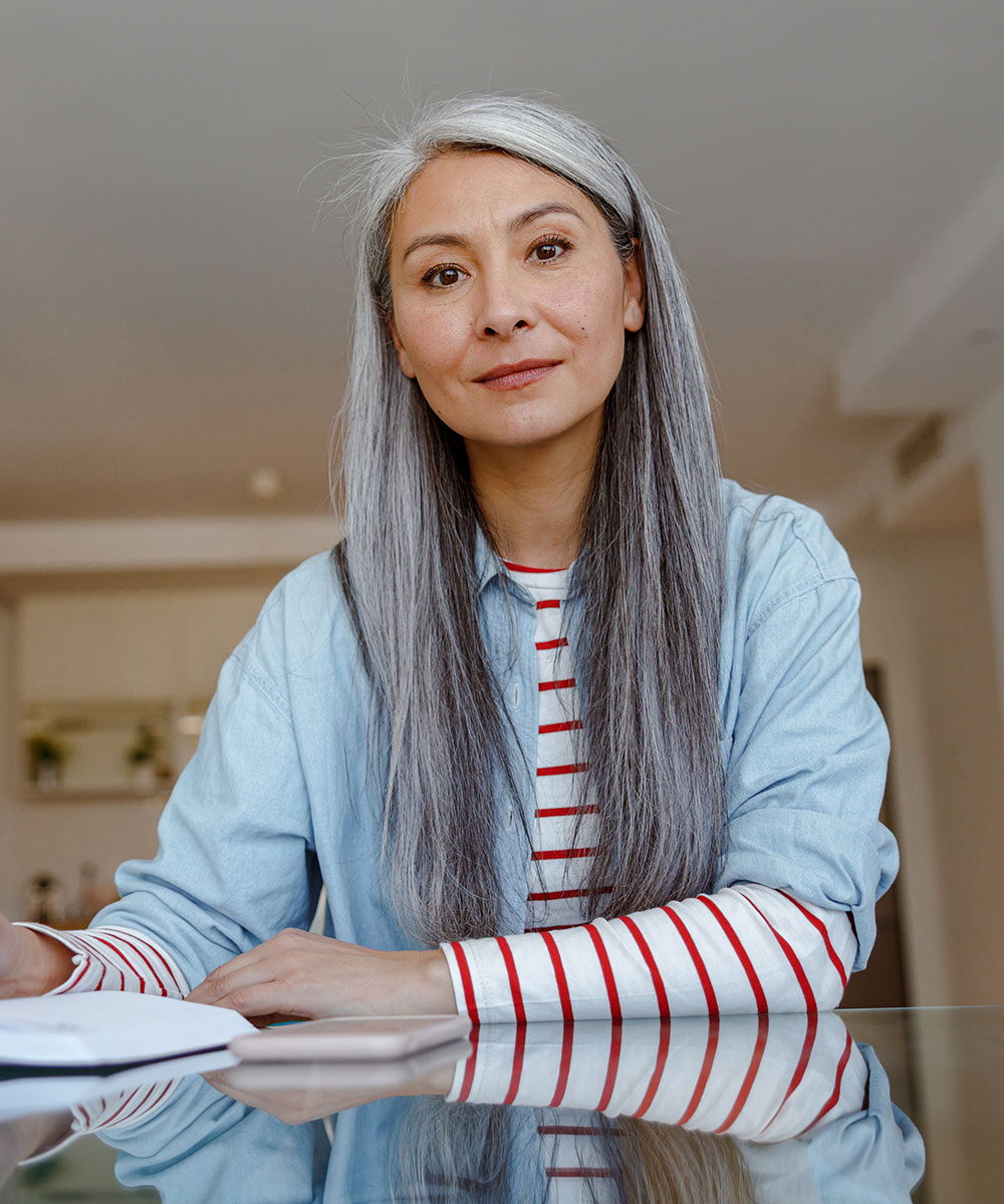 woman sitting at the table and taking notes at hom CY667L5