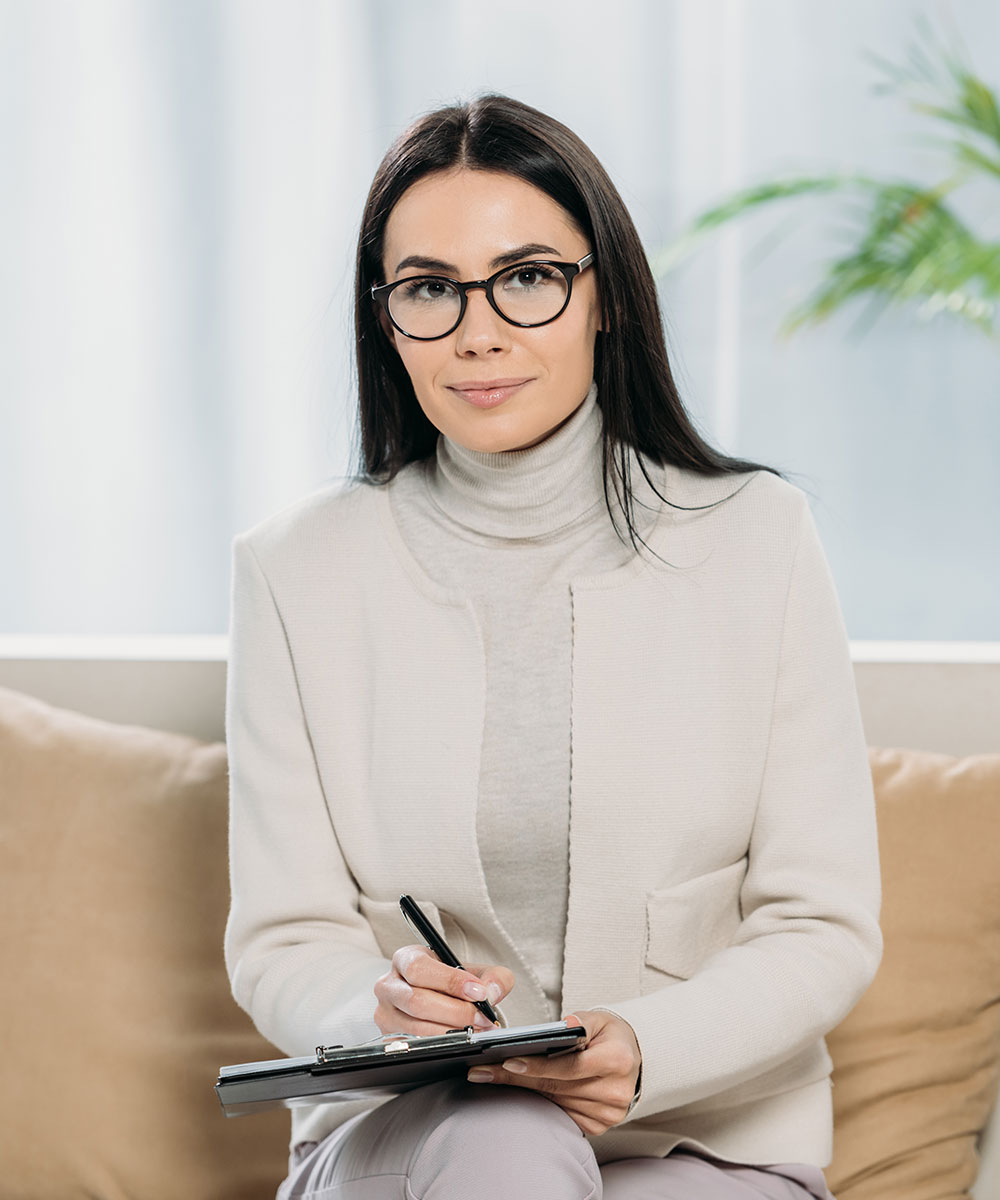 young female psychologist in eyeglasses writing on W24GVKH