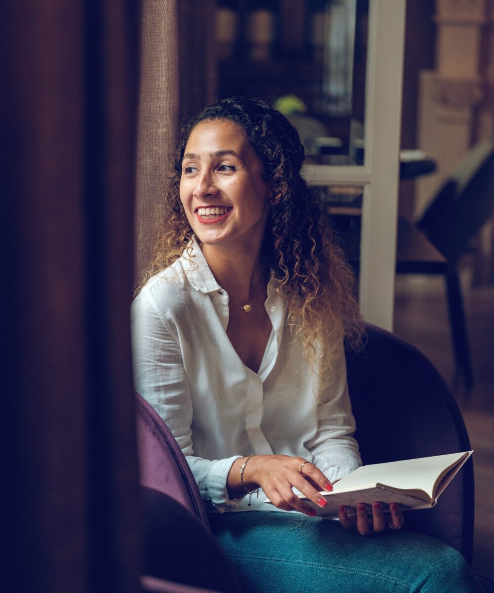 cheerful-ethnic-woman-reading-book-in-cafe.jpg